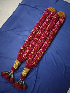 a bunch of beads laying on top of a blue sheet with red and yellow decorations