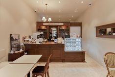 the inside of a restaurant with tables, chairs and an ice cream display case on the wall