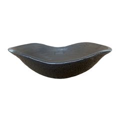 a black bowl sitting on top of a white wall