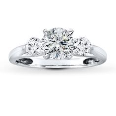 an engagement ring with three stones in the center and two round diamonds on each side