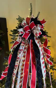 a christmas tree decorated with red, white and black ribbons