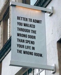 a sign hanging from the side of a building that says, better to admit you walked through the wrong door than spend your life in the wrong room