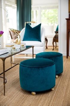 a living room filled with furniture and a coffee table in front of a window on top of a rug