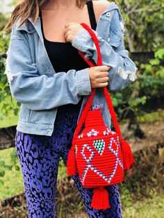 These are traditional Moroccan bread baskets with a twist. Handmade by artisans in Morocco, these bags can we worn as a purse or used to hold your favorite plant in your home. Each bag is one of a kind, no two are the same! DETAILS Cotton covered woven straw Made using the same technique as Moroccan bread baskets Ethically Handmade in Morocco Bag has lid closure Designed in Delray Beach, FL MEASUREMENTS Width 6” in Height Without Top 6.5” in Height With Top 11” in Tassel Length 4”in Strap Drop 1 Artisan Handwoven Bucket Bag, Artisan Woven Bucket Bag, Weaved Bucket Bag, Red Handmade Bucket Bag For Beach, Bohemian Woven Bucket Shape Shoulder Bag, Bohemian Woven Bucket Shoulder Bag, Handwoven Red Crochet Shoulder Bag, Red Handwoven Crochet Shoulder Bag, Red Woven Crochet Bag For Market