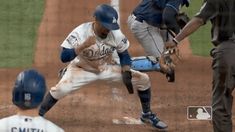 a baseball player holding a bat next to home plate with umpire and catcher behind him