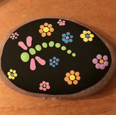 a painted rock sitting on top of a wooden table