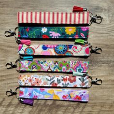 four zippers are lined up on top of each other, one is colorful and the other has floral designs