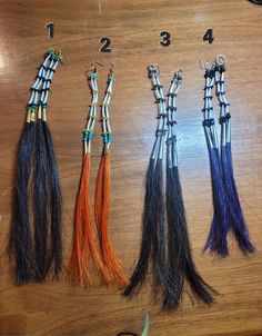 four different colored tassels on a wooden table