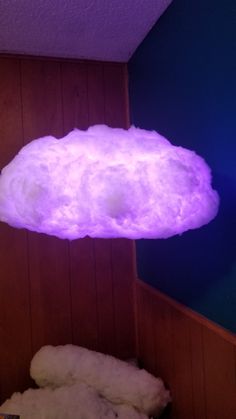 a purple cloud floating over a bed in a room