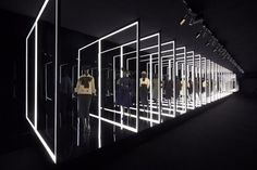 a group of mannequins standing in front of mirrors with lights on them