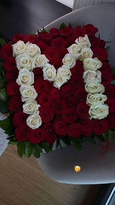 the letter m is made up of white and red roses in a heart - shaped arrangement