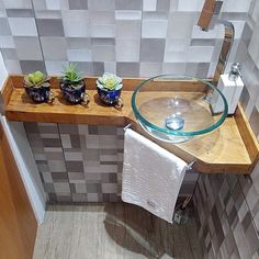 a bathroom sink with three succulents on it