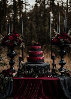 a red and black wedding cake surrounded by candles