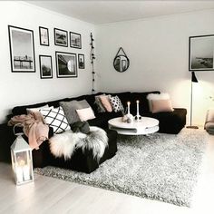 a black and white living room with pictures on the wall, rugs and furniture