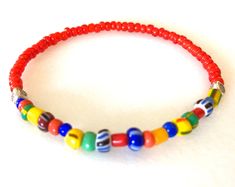 "Colorful African \"Love\" beads mixed with bright red white heart glass beads and Karen Hill Tribe fine silver on a skinny stretch bracelet. These colorful skinny bracelets are trending now in Europe for both men and women! Fun for summer! The 3-4mm multicolored vintage Czech glass beads are handmade in varying sizes and shapes. Originally made to be sent to Africa. The bright red handmade African glass beads are from Ghana and are called \"white heart\" beads because of the pure white painted Adjustable Red Beaded Bracelets With Large Beads, Red Beaded Bracelet With Colorful Beads For Beach, Red Beaded Bracelets With Heart Beads For The Beach, Red Beaded Bracelets With Letter Beads For Beach, Red Beaded Bracelets For Beach, Red Beaded Bracelets With Colorful Beads For Beach, Red Beaded Necklaces With Letter Beads, Red Beaded Necklace With Letter Beads, Red Bracelets With Letter Beads