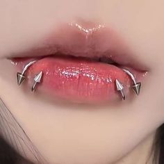 a woman's lips with three metal spikes on the top of her lip and bottom part