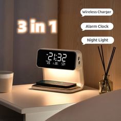 an alarm clock sitting on top of a white table next to a cup and candle