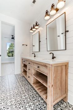 a bathroom with two sinks and three mirrors