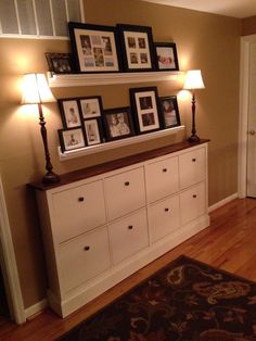 a living room filled with furniture and pictures on top of the dresser next to a doorway