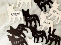 dog cutouts with names on them sitting on a marble countertop in black and white