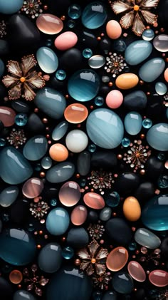 many different colored stones and flowers are arranged in the shape of an abstract pattern on a black background