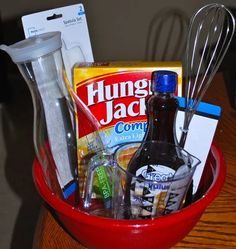 a red bowl filled with kitchen items on top of a wooden table