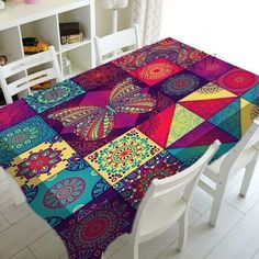 the table is covered with colorfully designed placemats and chairs in front of a white bookcase