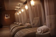 a row of chairs sitting next to each other with towels on top of them in front of sheer curtains