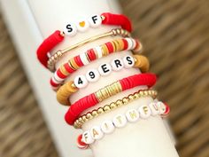 "San Francisco 49ers stackable heishi polymer clay bracelet(s.) Perfect for game days. All gold spacer beads are 18k gold filled. *Some color shades may vary some.  *EACH BRACELET SOLD SEPARATELY. Right colors, but wrong team? Message seller to customize yours with your favorite team, mascot or slogan.  INSTRUCTION: 1. Select wrist size from the drop down menu. Each bracelet is custom made to size. (Please see photo for wrist sizing measurement.) 2. In the \"Personalization\" section, please notate any changes you would like to make. Examples of this would be letter bead color or word change. (Please indicate letter color of \"NINER GANG\"  bracelet in PERSONALIZATION SECTION.) If letter color choice has not been mentioned in this section, seller will automatically make letter color the sa Sporty Red Jewelry For Game Day, Keep Bracelet, Football Bracelet, San Francisco 49ers Football, Polymer Clay Bracelet, 49ers Football, Word Bracelet, Clay Bracelet, Polymer Jewelry