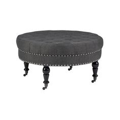 a round ottoman sitting on top of a black wooden table with studded trimmings