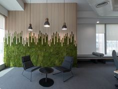 an office with moss growing on the wall and two chairs sitting in front of it