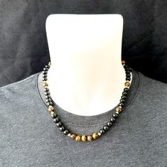 ► ► If you are looking for a unique choker necklace with Fashionable Tiger Eye Onyx beads, this product is for you! ► Size and details: ► ► Necklace Designed with stainless steel rope. Not parachute rope or fishing rod! It is extra durable and AAA quality. ► ► You can buy our Tiger Eye and Onyx Beaded Necklace with 6mm or 8mm bead options! ► ► The necklace is designed with 8mm black Onyx stones, 8mm tiger eye stones and 4mm Gold colored bit stones. ► ► The necklace length you see in the pictures Spiritual Black Jewelry With Polished Beads, Adjustable Hematite Necklace With Black Beads, Black Necklaces With Round Natural Stones, Onyx Black Beads Necklace As A Gift, Black Beaded Necklaces With Natural Stones For Gifts, Onyx Beaded Necklace With Black Beads As A Gift, Adjustable Black Beaded Necklace With Gemstone Beads, Adjustable Black Gemstone Beaded Necklace, Spiritual Hematite Necklace With Black Beads