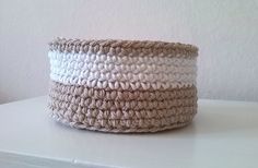 a white and beige basket sitting on top of a table