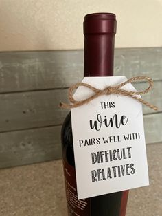 a bottle of wine with a sign on it that says, this wine pairs well with difficult relatives