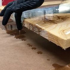 a person standing on top of a piece of wood next to a puddle of water