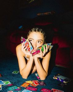 a woman laying on the floor holding up cards