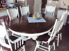 a dining room table with white chairs around it