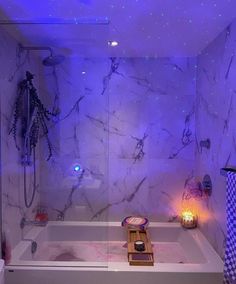 a white bath tub sitting under a purple light