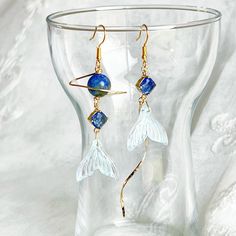 Mermaid Tail and Blue Planet Earrings Our Mermaid Tail and Blue Planet Earrings are perfect as a gift, with carefully crafted mermaid tails and brilliant blue planets encapsulated in sterling silver frames. Quality jewelry, sure to capture and captivate the gaze of its admirers. As a gift shop, we offer a complimentary gift box for every order. Detail: Length of earring - around 80mm; size of bead - around 8mm Material: ear wire - sterling silver; wire and drops - gold-plated bronze; beads - lapis lazuli bead Note: the Mermaid Tail and Blue Planet Earrings are handmade locally in the UK, each pieces would vary slightly in detail.  About postage: Standard postage When choosing standard postage, we assume this order is for yourself, or you will wrap the item yourself before giving it out as Ocean-inspired Blue Dangle Earrings, Blue Dangle Earrings With Ocean-inspired Style, Ocean-inspired Blue Earrings With Ear Wire, Handmade Mermaid Earrings For Gift, Ocean-inspired Single Earring As Gift, Ocean-inspired Blue Earrings For Gifts, Blue Ocean-inspired Dangle Jewelry, Celestial Blue Single Earring, Silver Wreath