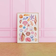 a pink wall with shells and starfish on it in front of a wooden floor