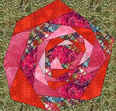 a pink and green quilt with a circular design on the center, surrounded by leaves