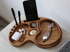 a cell phone and some glasses on a wooden tray next to a computer mouse pad