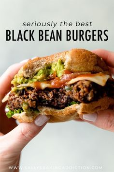 a hand holding a sandwich with black bean burgers