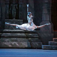 a woman in white is performing on stage