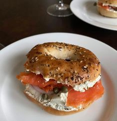 a bagel sandwich with salmon and capers on it sitting on a white plate