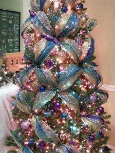 a christmas tree decorated with ribbons and ornaments