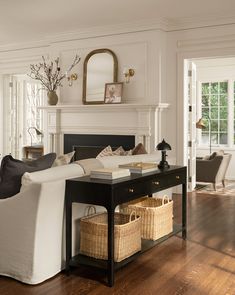 a living room filled with furniture and a fire place next to a table in front of a fireplace