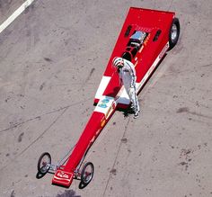 an aerial view of a race car on the ground with wheels attached to it's rear end