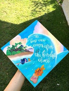 someone is holding up a graduation cap with an ocean scene and words on the front