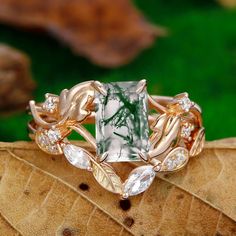 a green and white ring sitting on top of a leaf